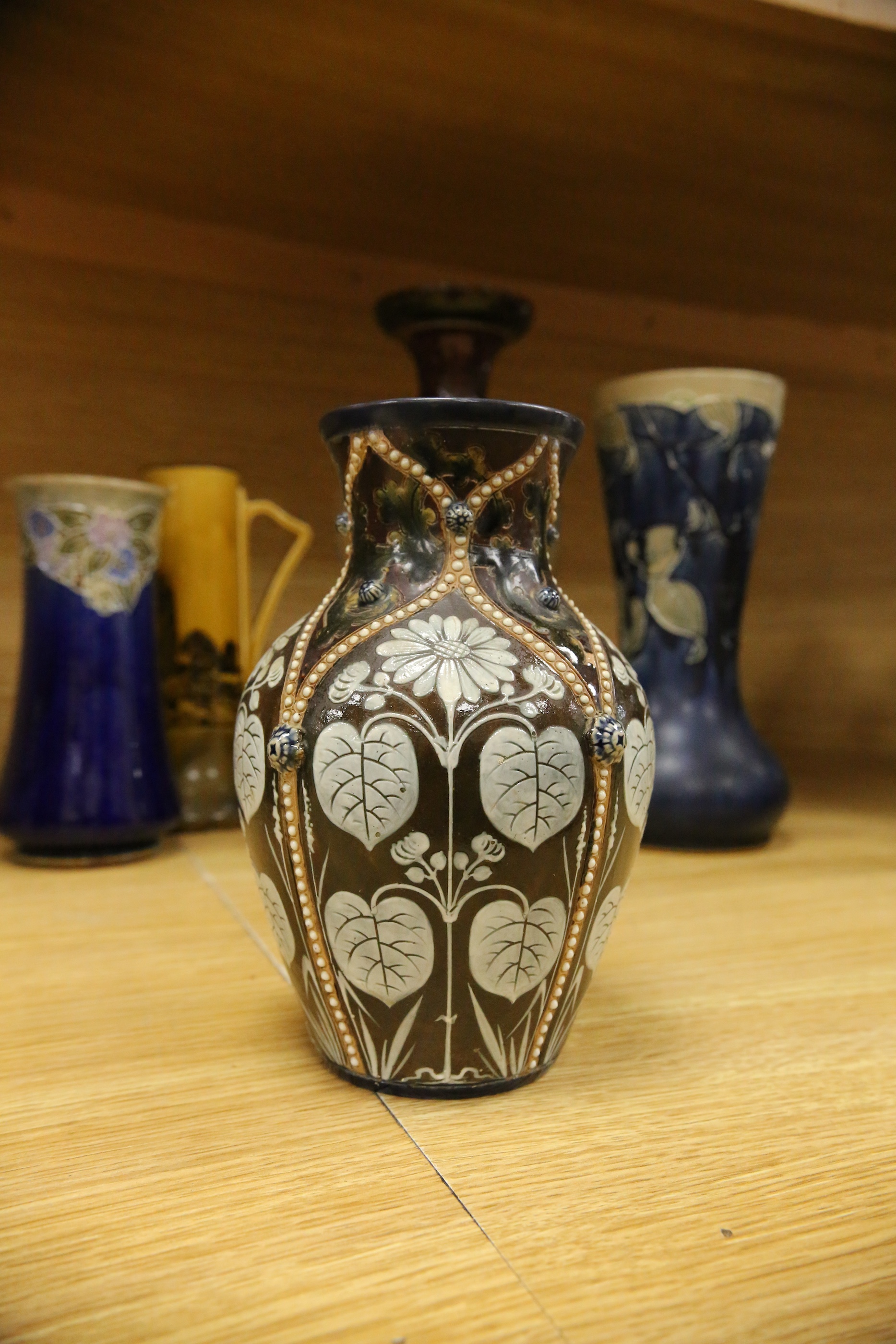 Four Royal Doulton vases and a yellow glazed jug items, tallest vase 34cm high. Condition - some crazing and faults, large vase has damage to lower neck
